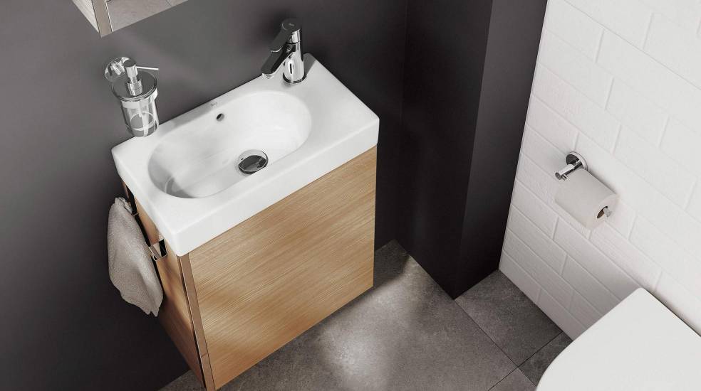 Esta casa de banho compacta é transformada com um pequeno armário de casa de banho, mostrando que menos é mais em termos de design e funcionalidade.